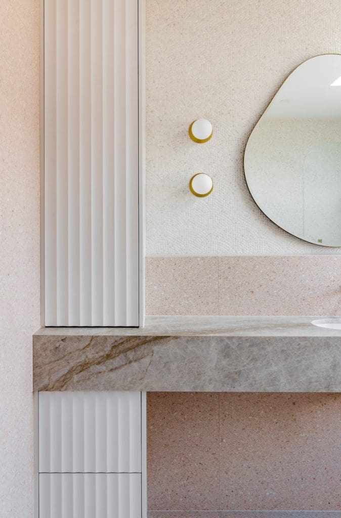 Round wall lights with gold circular back in the bathroom