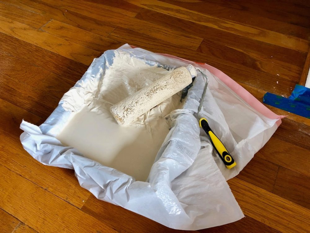 Plastic bag over paint roller tray is a home painting hacks