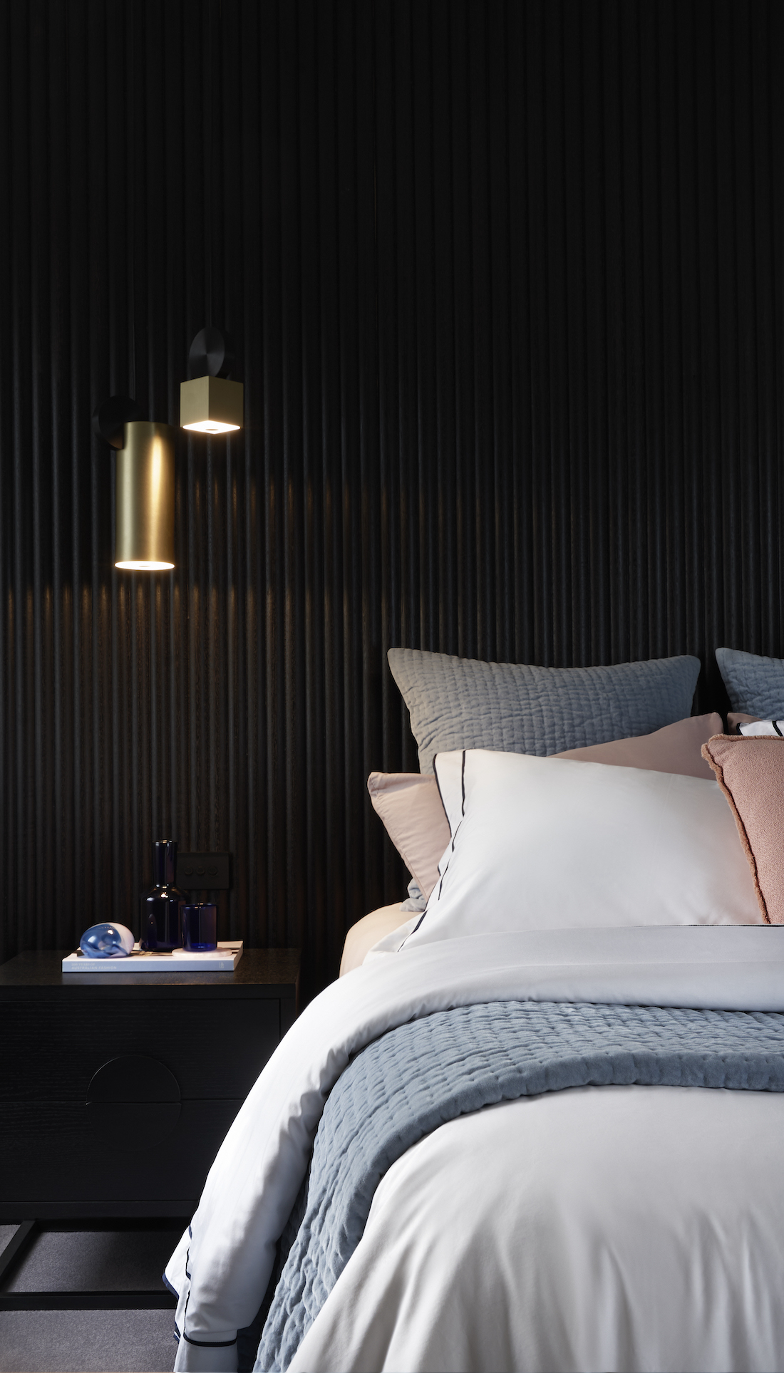Black bedroom wall with gold pendant light