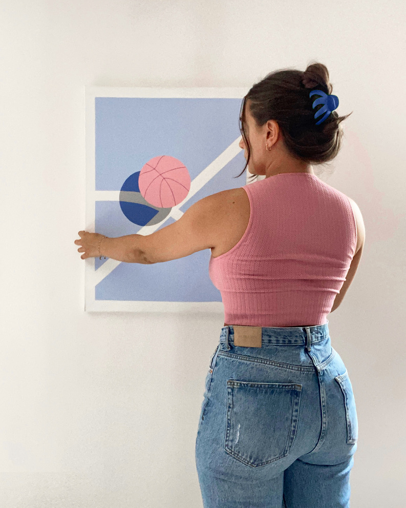 Léa Gadenne from LeaColorShapes placing art on wall