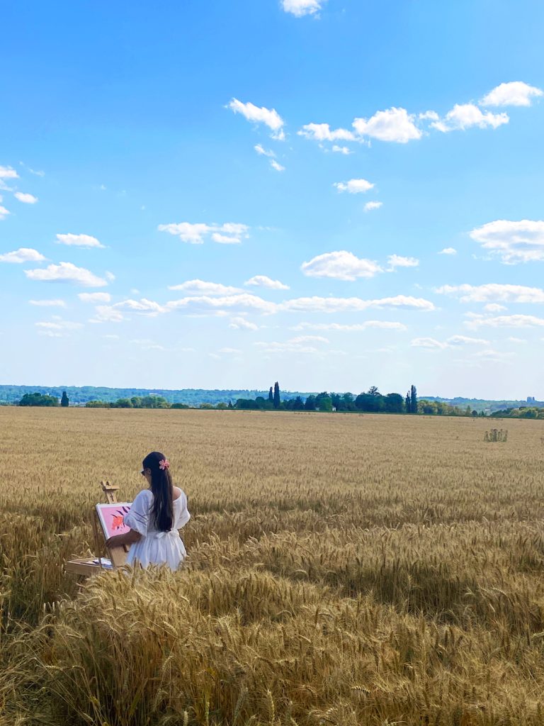 Léa Gadenne painting in a field