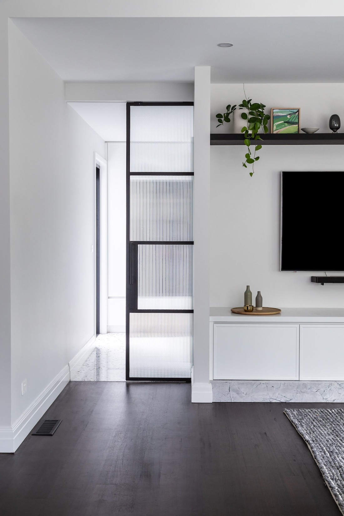 Reeded glass door separating living room and mudroom in Wattle Valley Road by Picchio Interiors