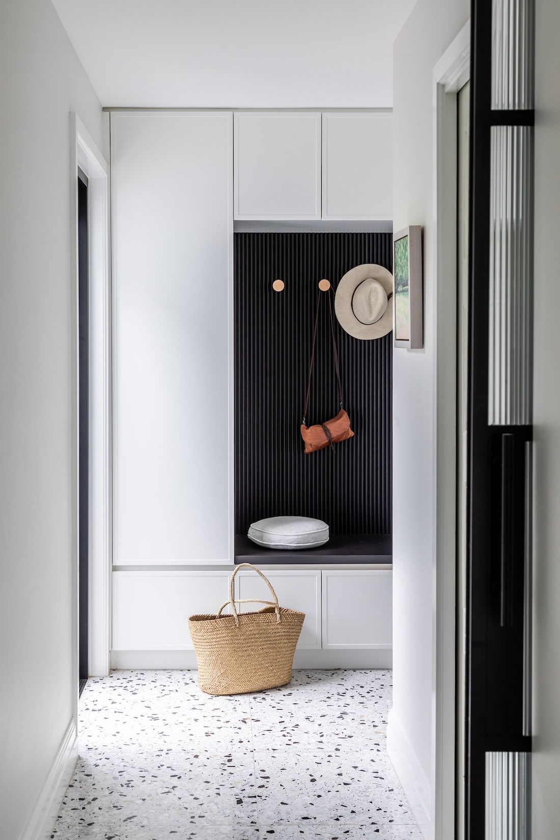 White mudroom with black seated area in Wattle Valley Road by Picchio Interiors