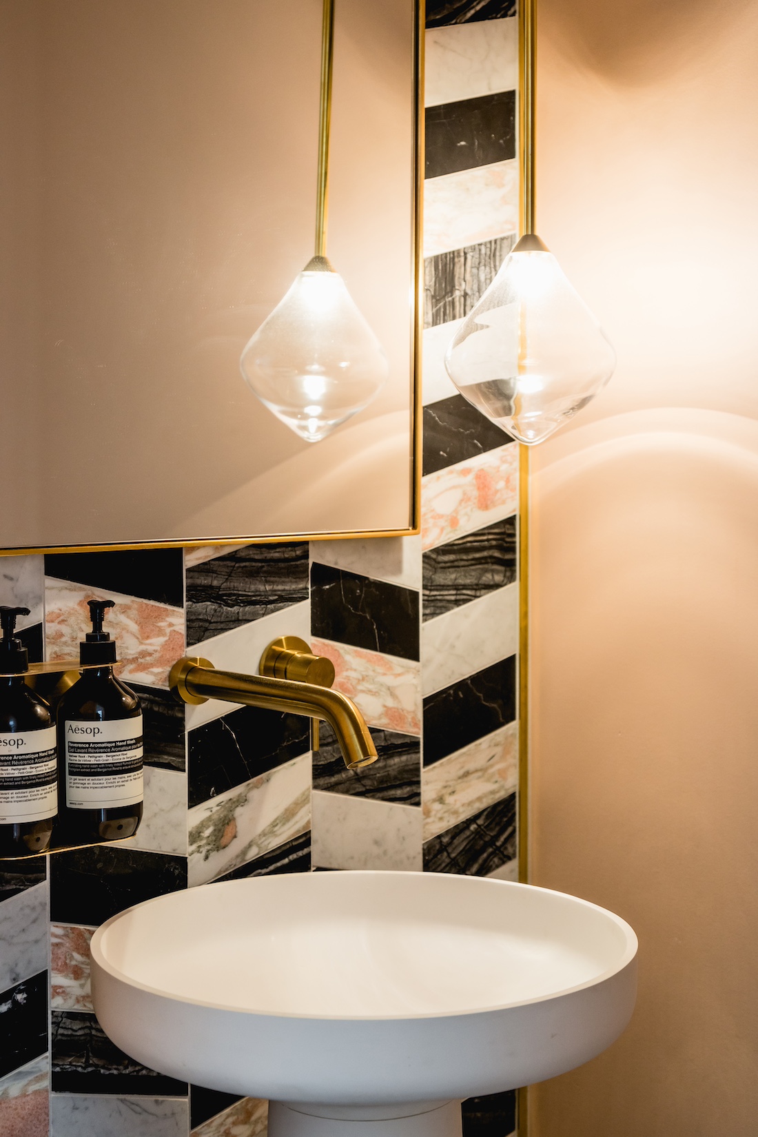 Carnegie Cottage black and white mosaic tiled wall with powder room pedestal bathroom