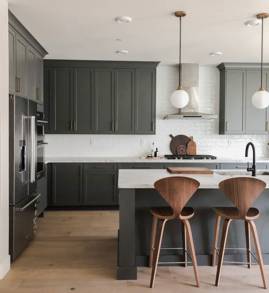 Green cabinetry and island bench in kitchen