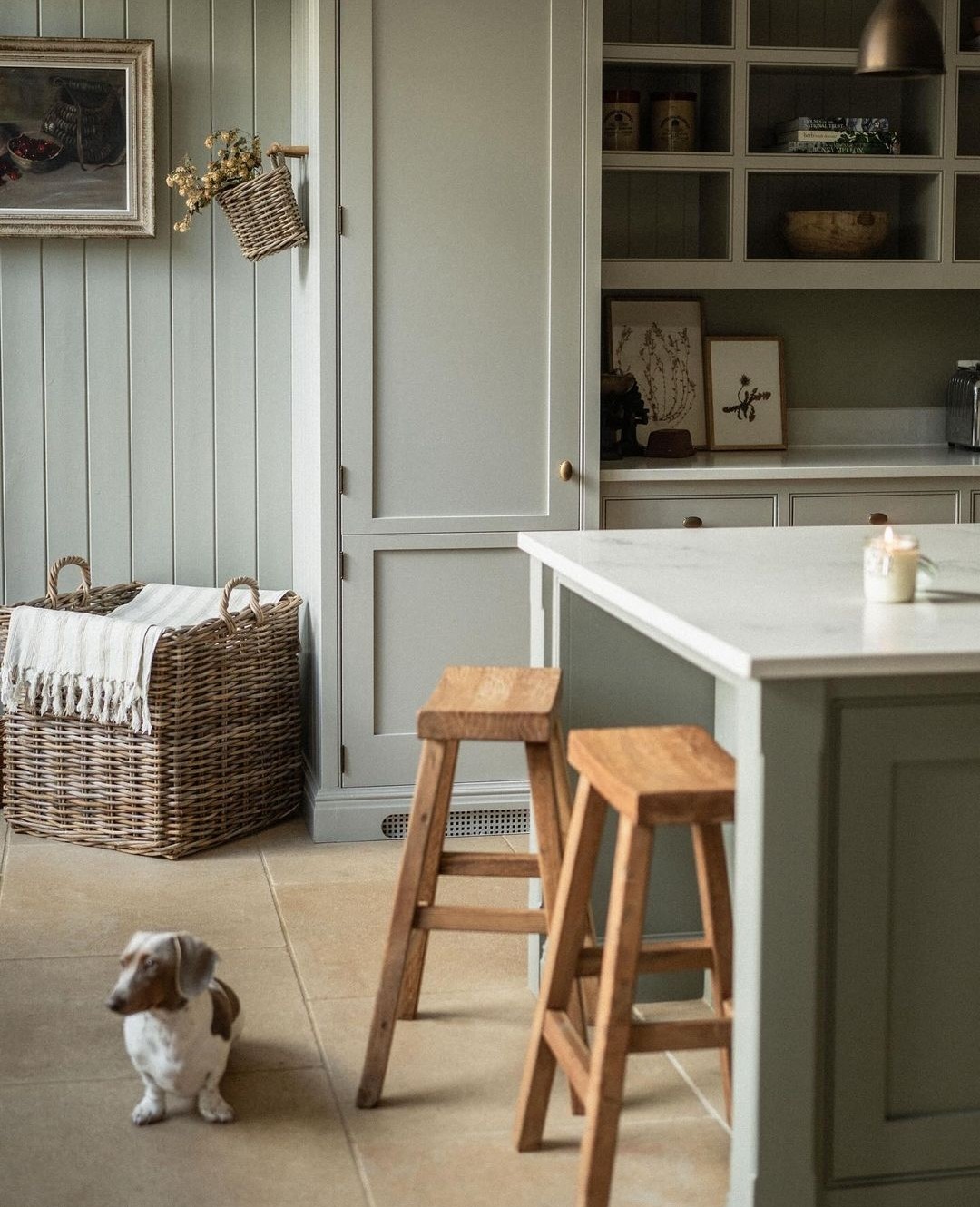 Pale green kitchen cabinetry and panelling in English kitchen