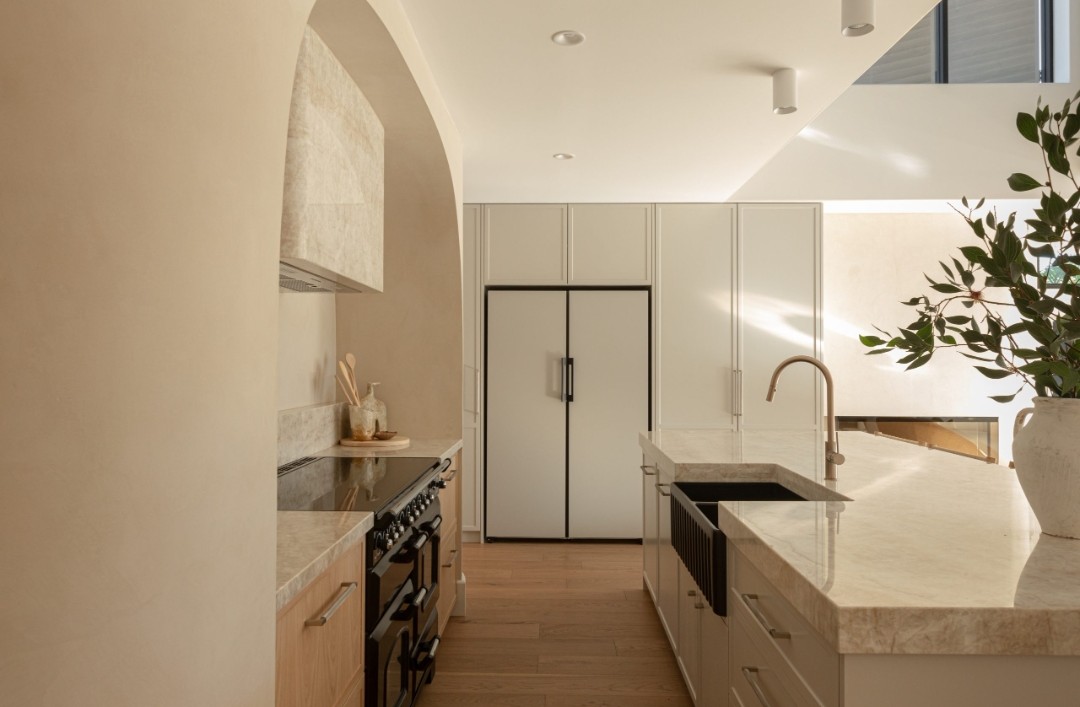 Kitchen with integrated appliances and curved details in Kyal and Kara Bay Builds