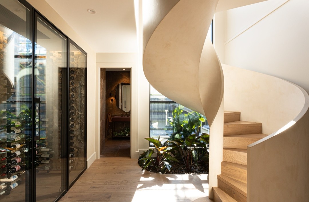 Curved staircase with indoor garden and wine room in Kyal and Kara Bay Builds