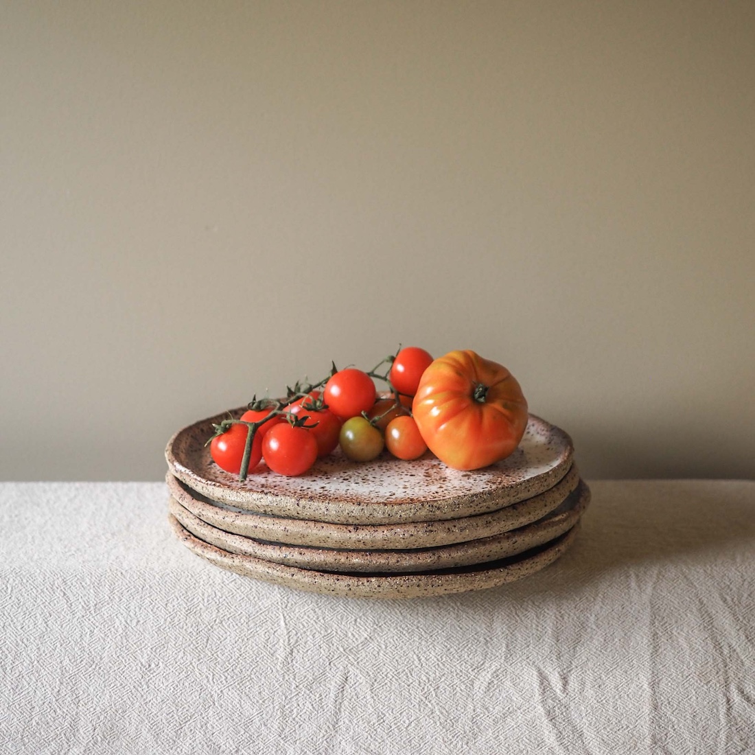 Stack of plates with tomatoes by Ochre Ceramics