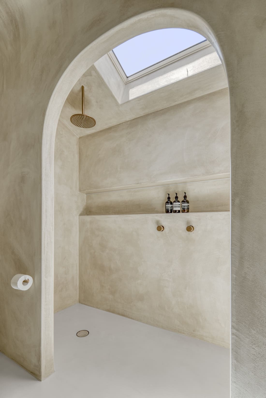 Curved entry to shower with skylight in Ruin X house