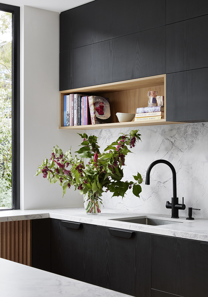 Sink and cookbook stack on timber shelf in kitchen of Elsternwick House