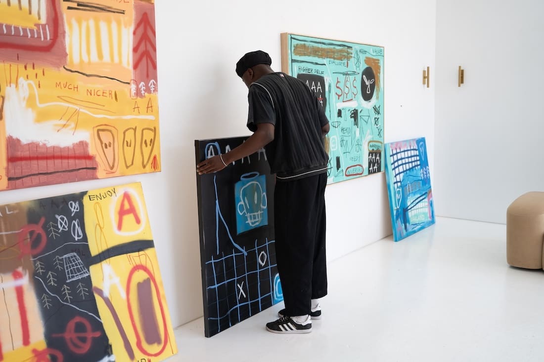 Musonga Mbogo in gallery with numerous bold street art style paintings