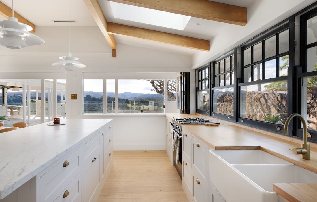 Modern kitchen with overhead beams and black framed windows at Rocklee House