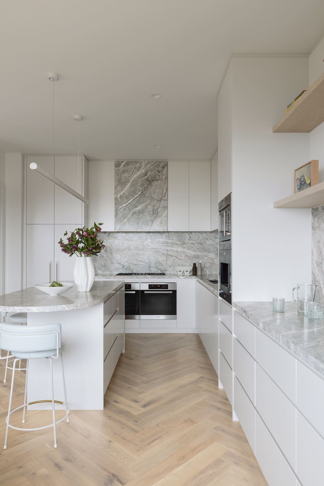 Integrated appliances in white and marble wrapped rangehood