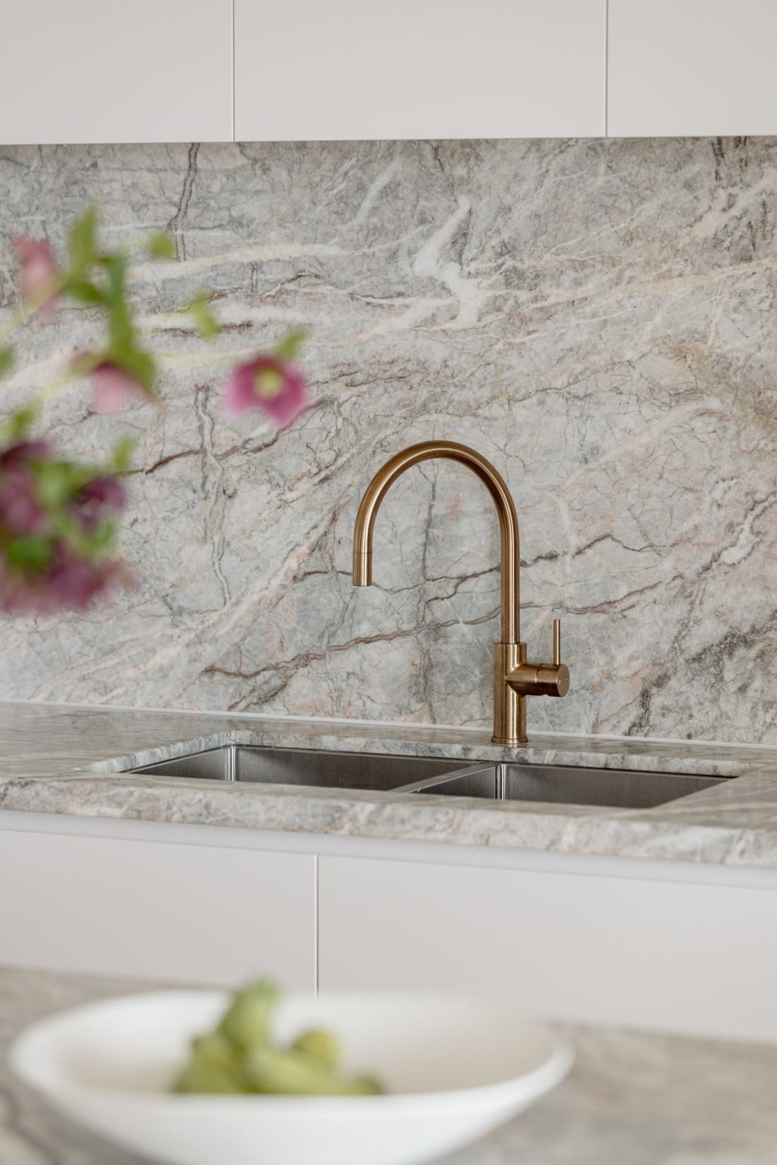 Marble stone splashback and brushed bronze tap