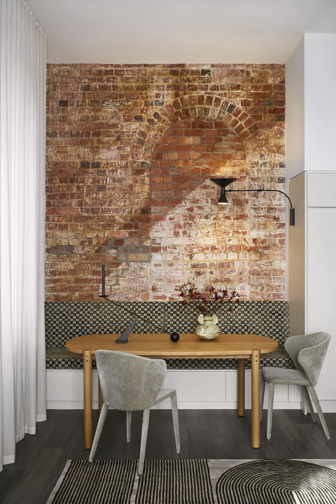 Exposed brick wall in dining nook of Tribeca Brewery apartment by The Stylesmiths