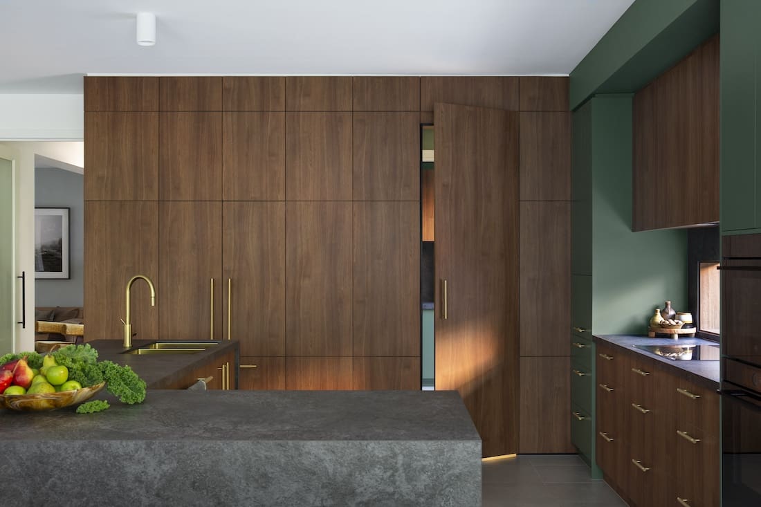 Timber cabinetry wall in kitchen of Warm Embrace residence by The Stylesmiths