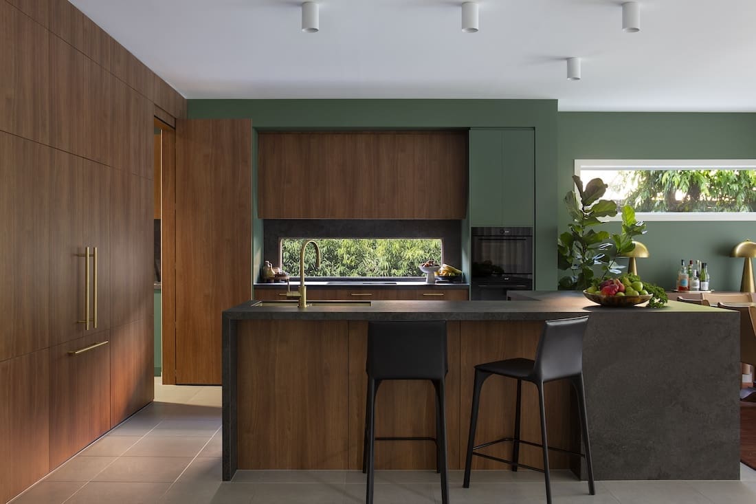 Green and timber kitchen in Warm Embrace residence by The Stylesmiths