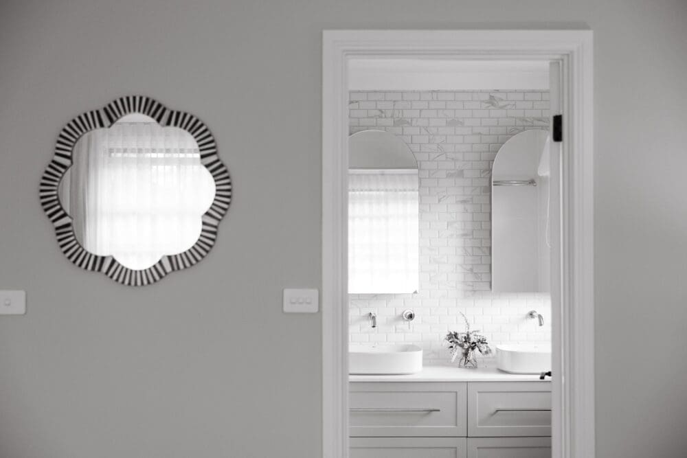 White bathroom with flower shaped mirror