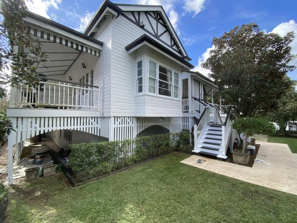 Queenslander home painted white with grey trim