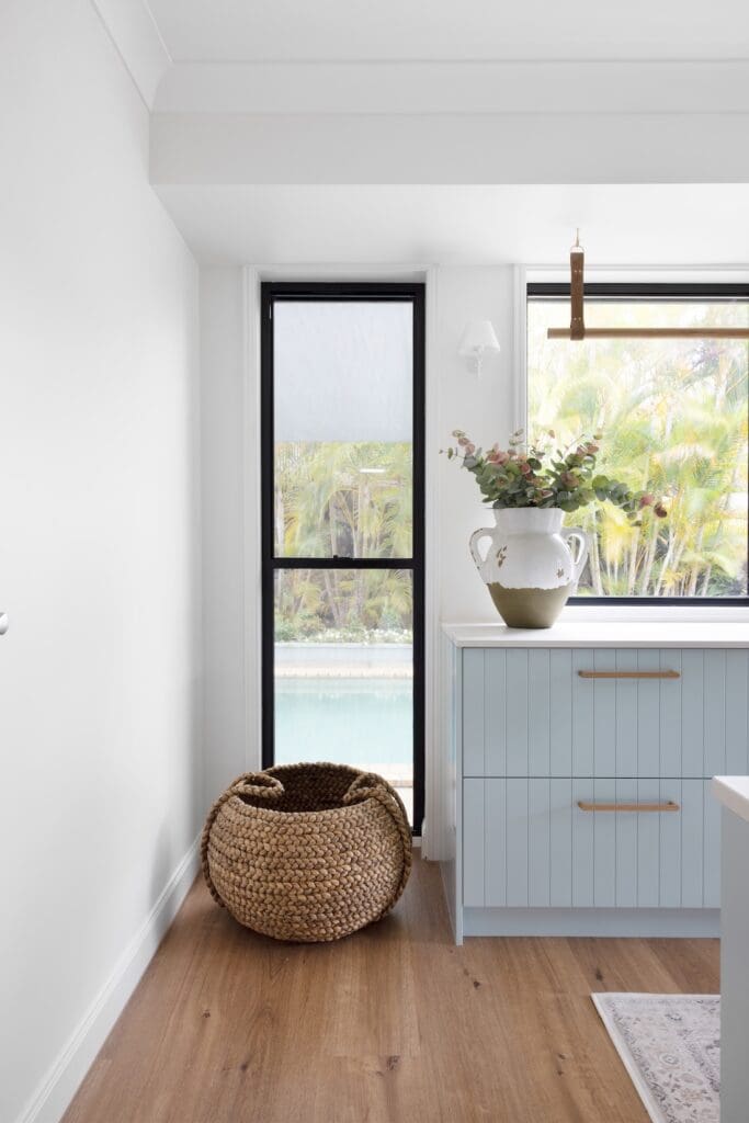 Laundry with blue cabinetry and hanging rail