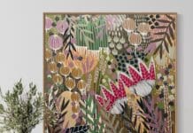 Colourful botanical artwork from B Twomey above a sideboard