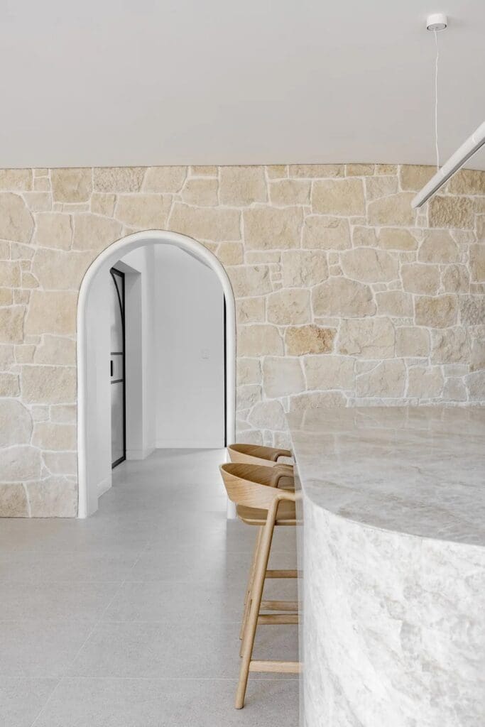 Natural stone wall with arch doorway at The Stables Burraneer House