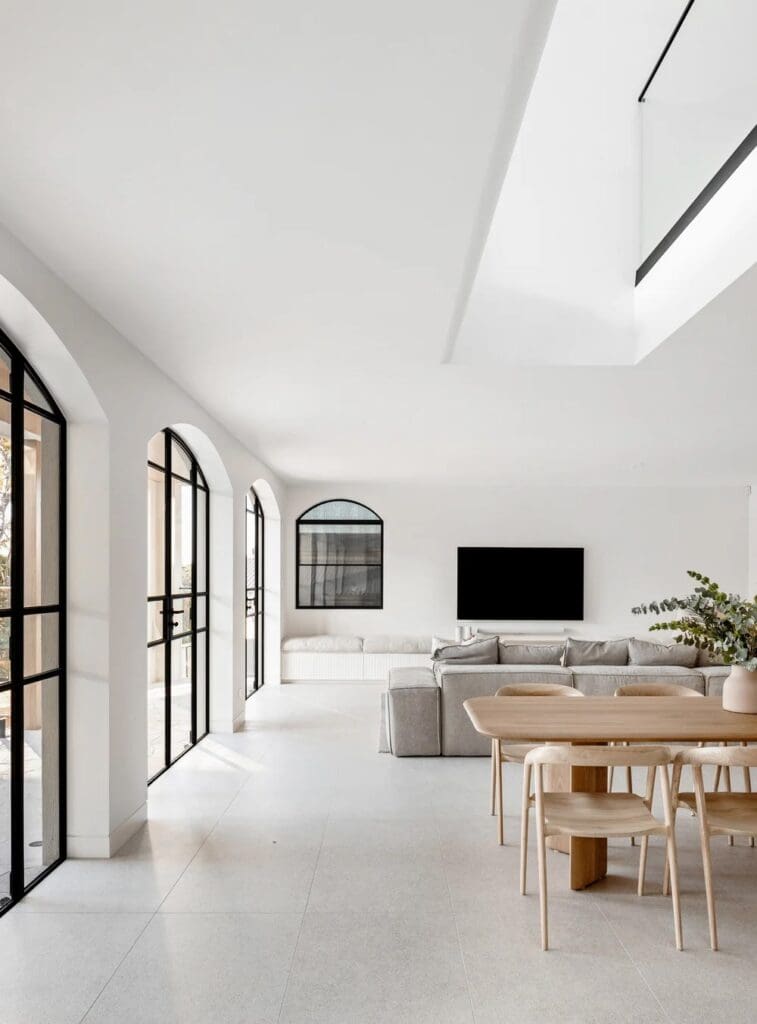 Black steel framed windows and doors in open plan living and dining space at The Stables Burraneer House