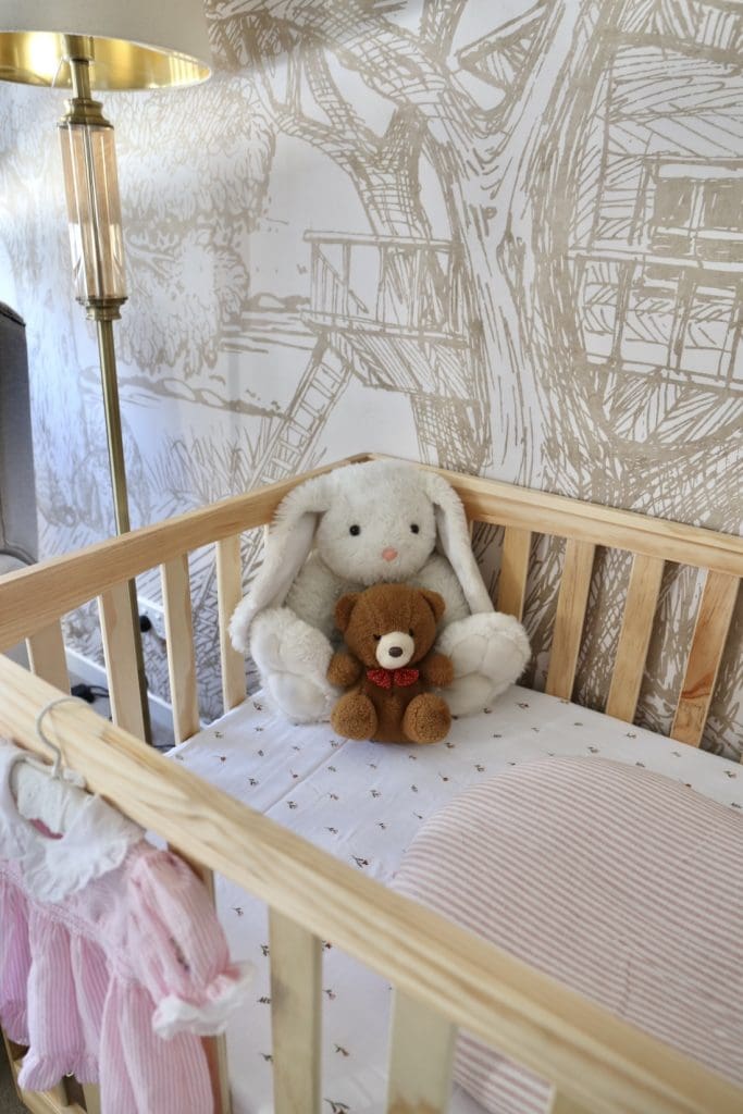Vintage toys in cot with woodland wallpaper