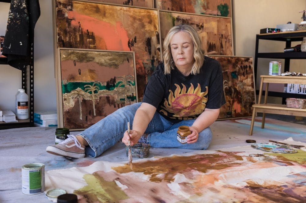 Bec Talbot in creative studio with abstract artworks displayed