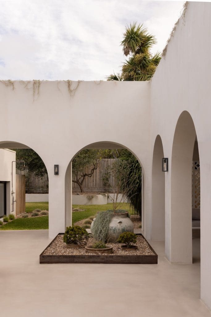 Exterior garden bed with archways at Coastal Alchemy by The Stylesmiths