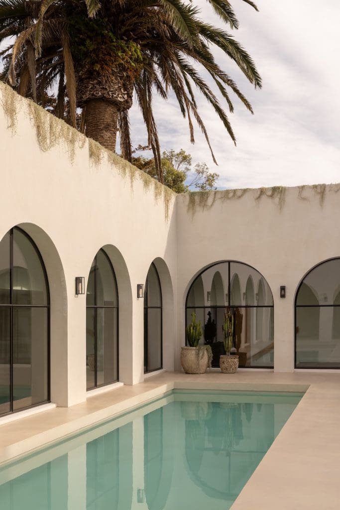 Arch mirrors surrounding courtyard pool at Coastal Alchemy by The Stylesmiths