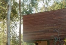 Edgars Creek House: A home that lives with the land Timber-clad architectural cabin with stacking doors opening to bushland, flat roofline and rustic fire pit set within a native garden.