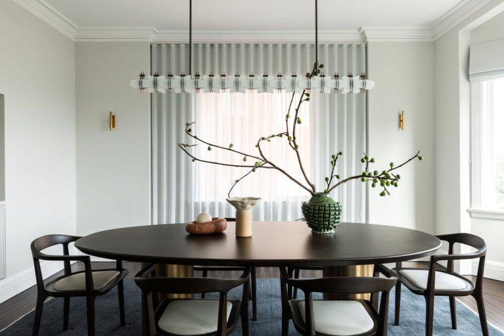 Round dining table with pendant light and sheer curtains