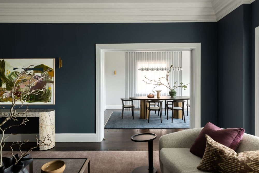 Living room with blue walls opening to dining room