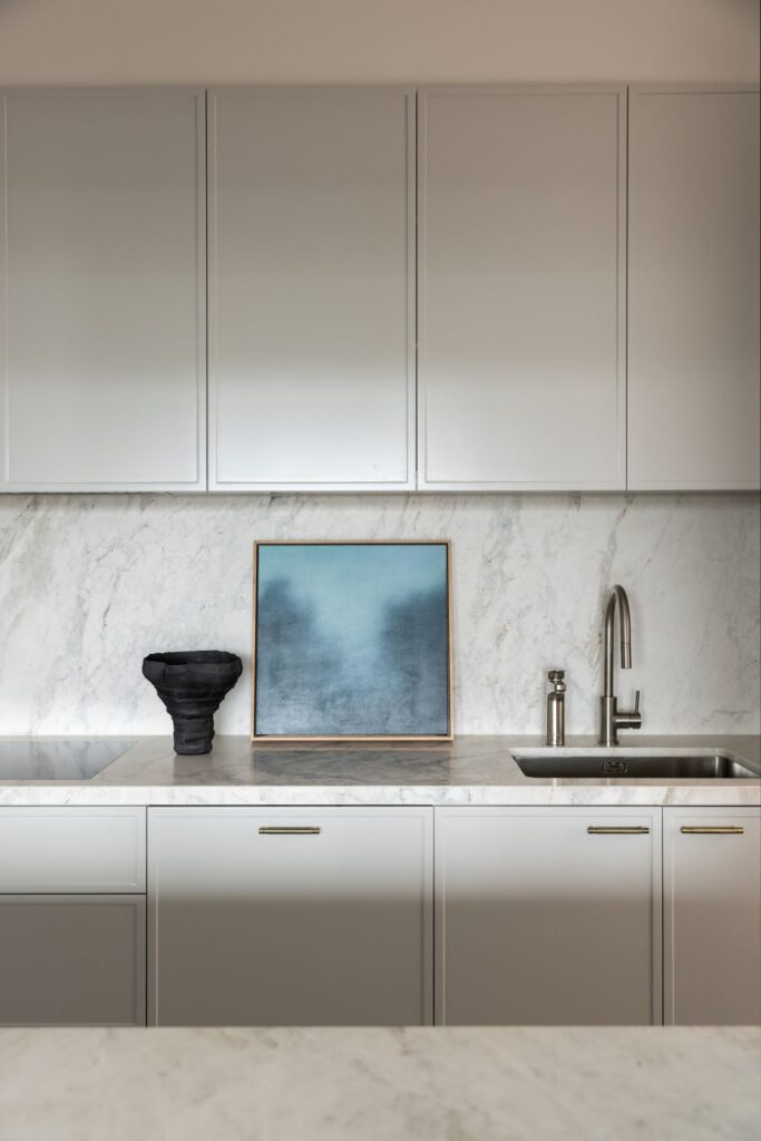 Marble splashback with neutral cabinetry in kitchen