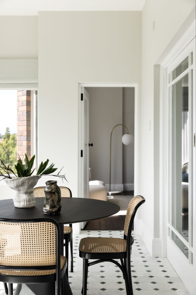 Round dining table with cane chairs and tiled floor