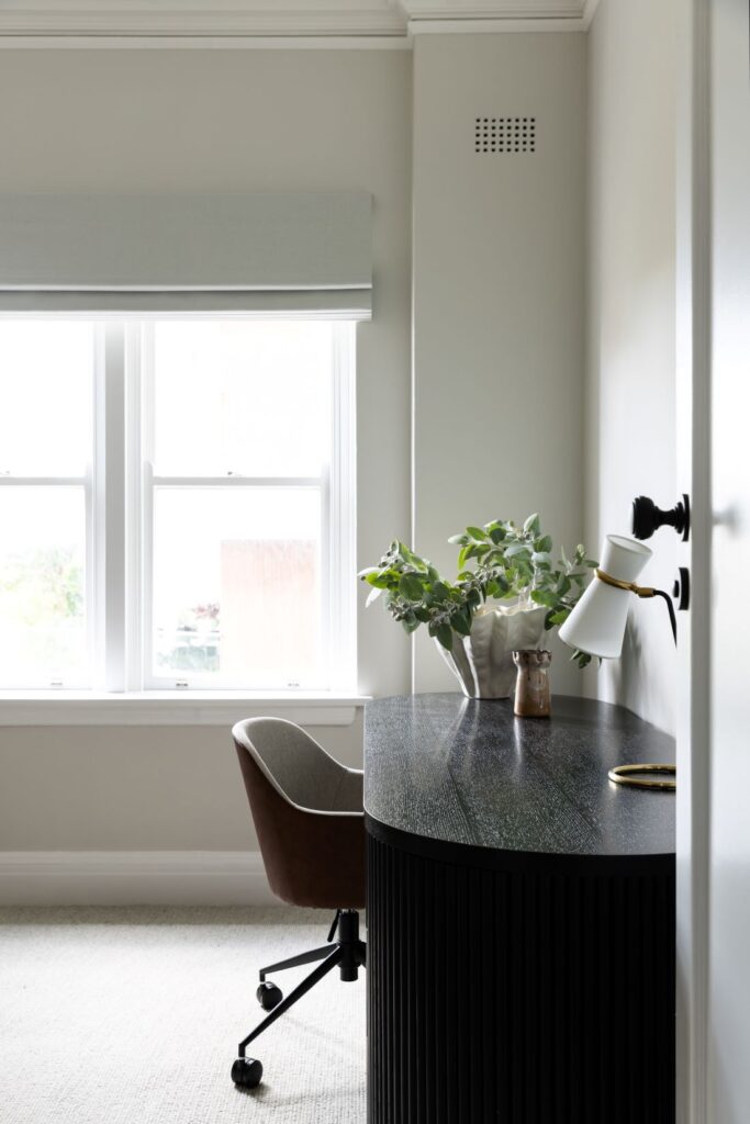 Small home office desk by window with greenery