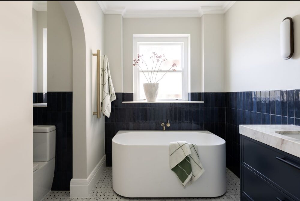 Freestanding bathtub with navy tiles in Art Deco bathroom
