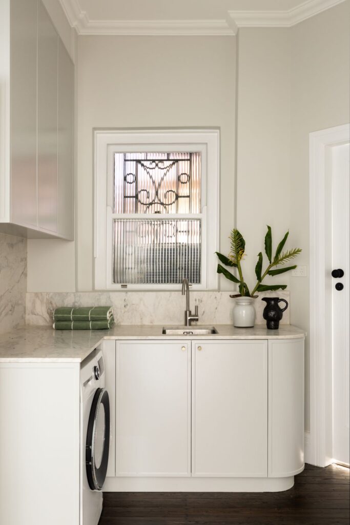 Compact laundry with marble bench and frosted glass window