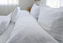 Close-up of white quilted bedding and pillows, with soft textures and natural light.