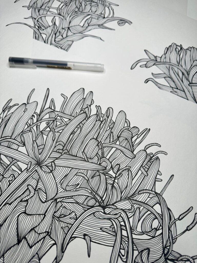 Close-up of the Looking Up illustration, featuring detailed black and white floral line art with a pen for scale.