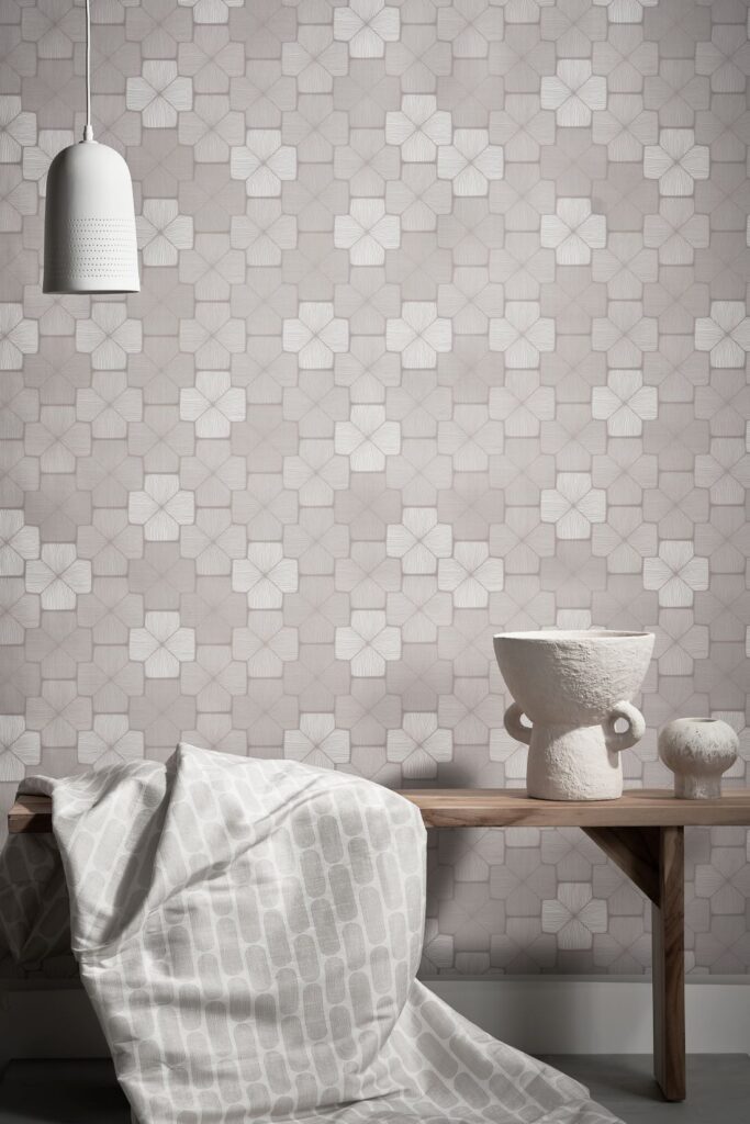 Stellar Wallpaper by Patricia Braune featuring a soft geometric floral design in light grey, paired with a wooden table, minimalist white ceramic vase, and cozy blanket.