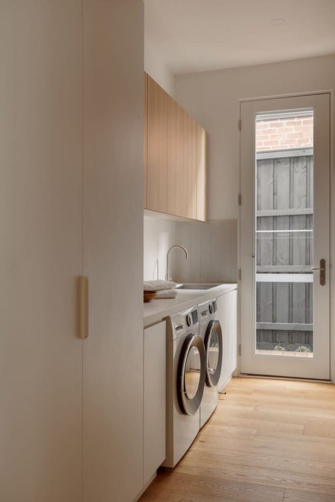 White and timber modern home laundry with vertical stacked subway tile splashback