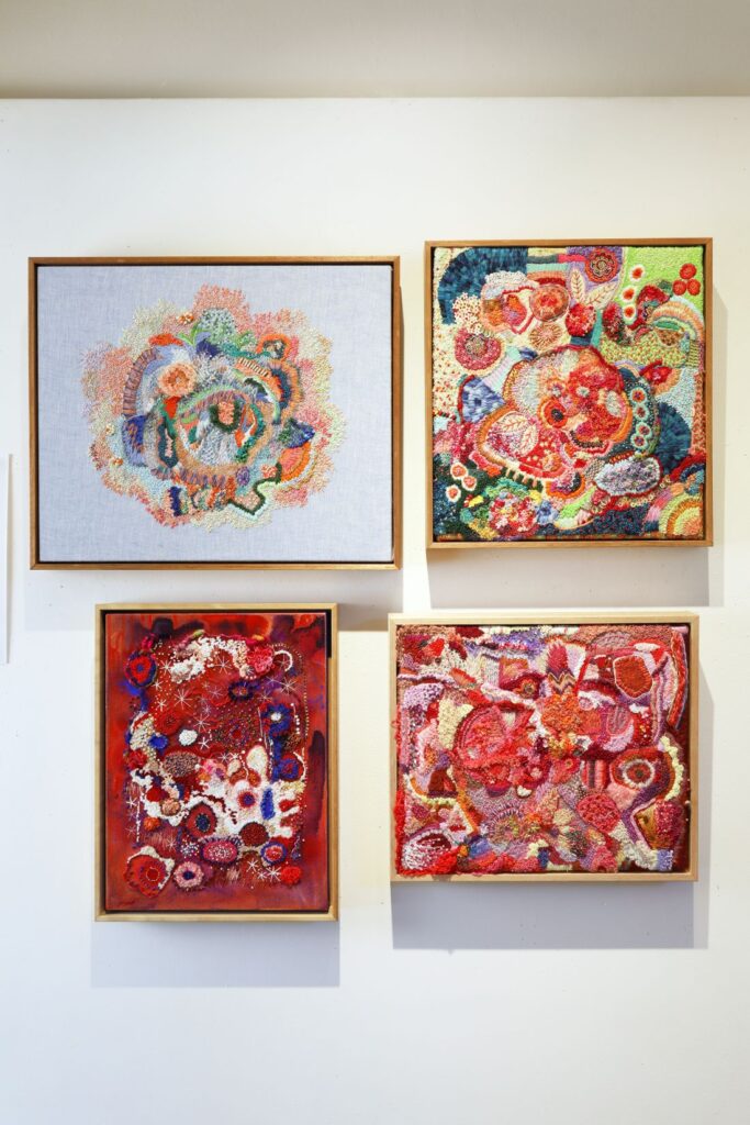 Colorful embroidery artworks in a gallery