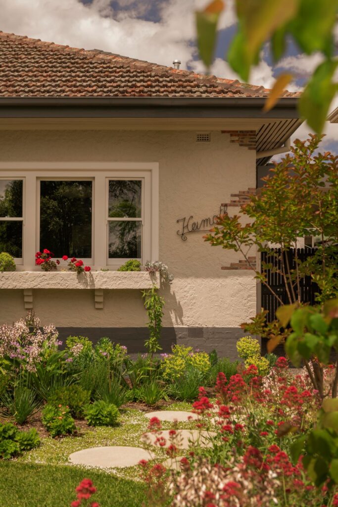 Close-up view of a Camberwell home's garden with blooming flowers, stepping stones, and a charming window box.