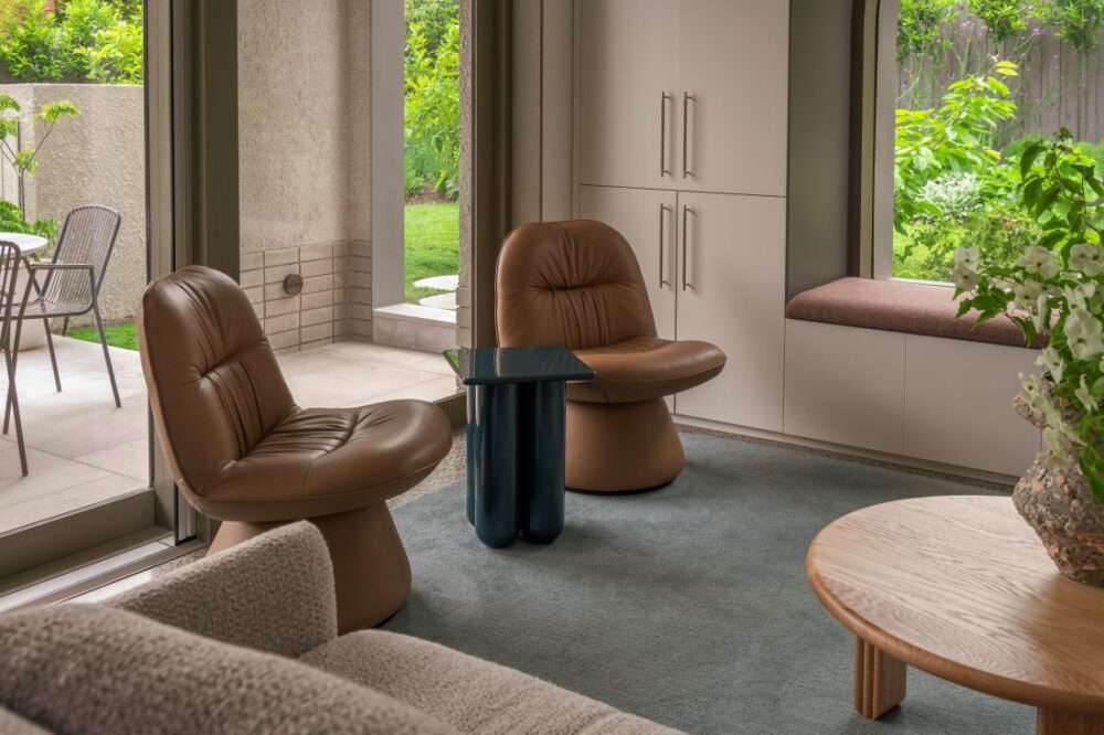 Contemporary lounge featuring comfortable chairs and a seamless transition to the lush garden outside.