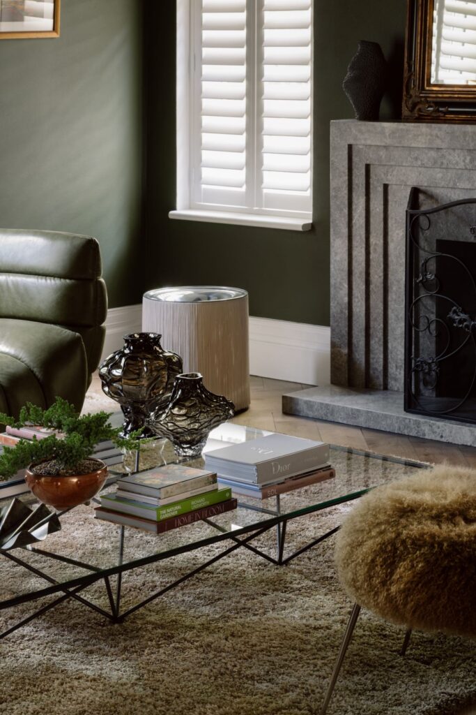 Close-up of a living room with a glass coffee table, designer books, and elegant accessories.