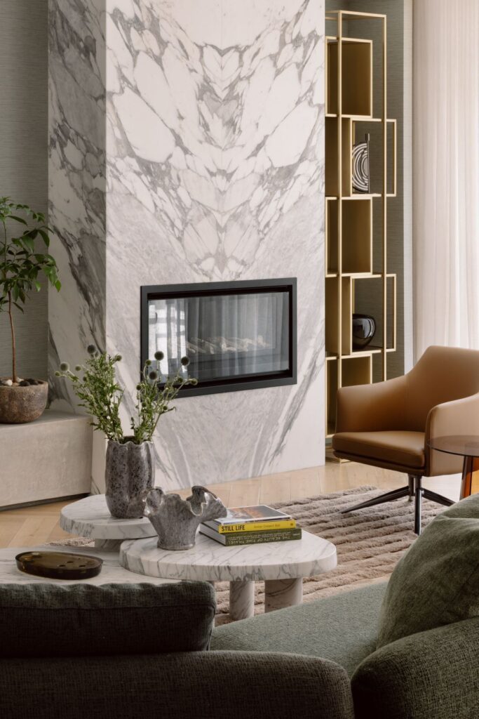 Modern living room featuring a marble fireplace, contemporary armchair, and unique decor.