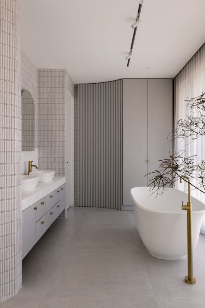 Elegant bathroom with a freestanding bathtub, dual sinks, and modern design elements.